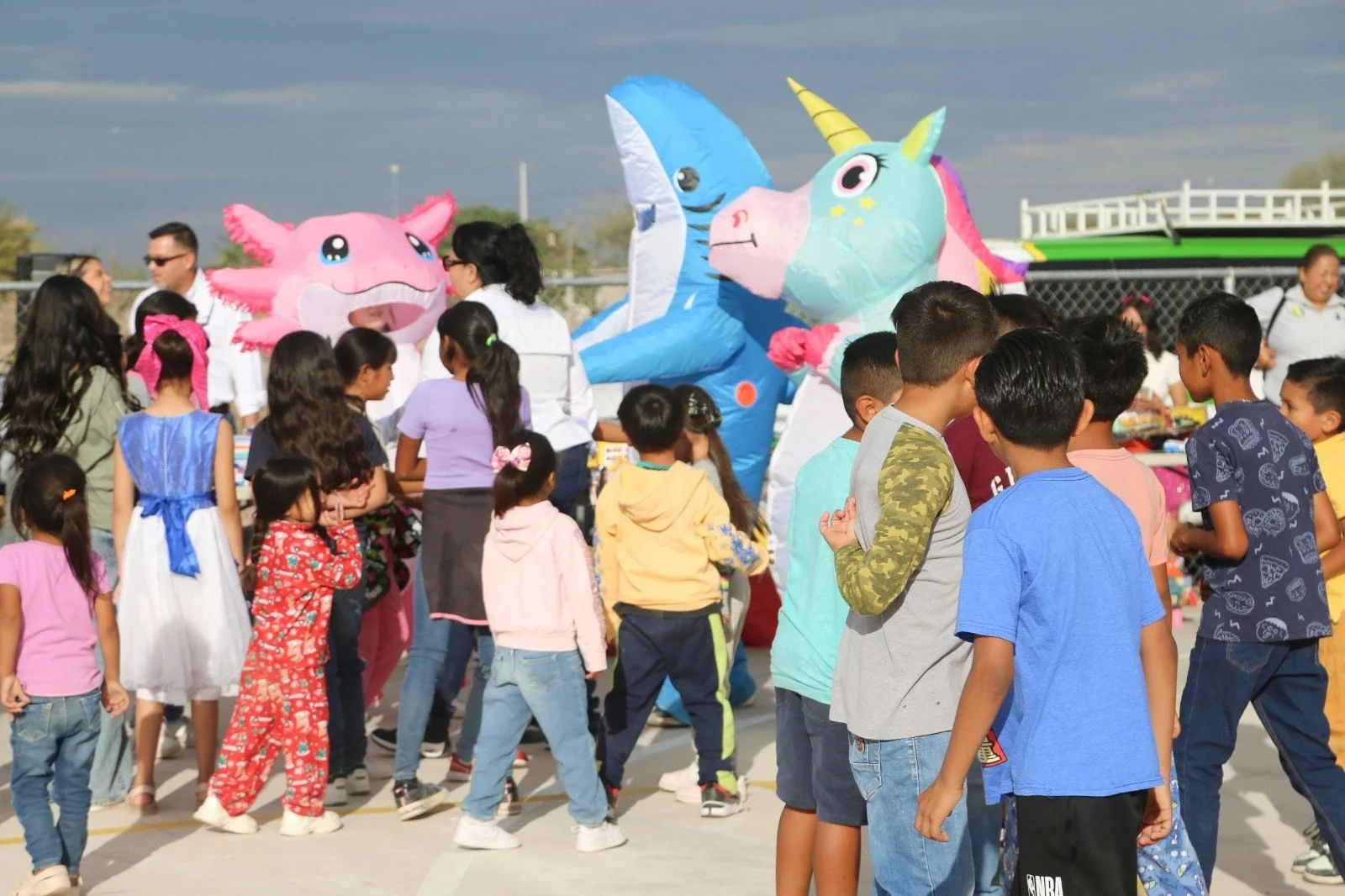 Niñas y niños participando en juegos con personajes inflables durante el Festival de la Niñez en la colonia San Isidro en Ciudad Constitución