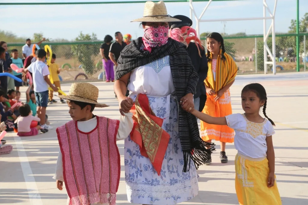 Niños y adultos con vestimenta tradicional caminando durante actividad cultural del Festival de la Niñez en San Isidro